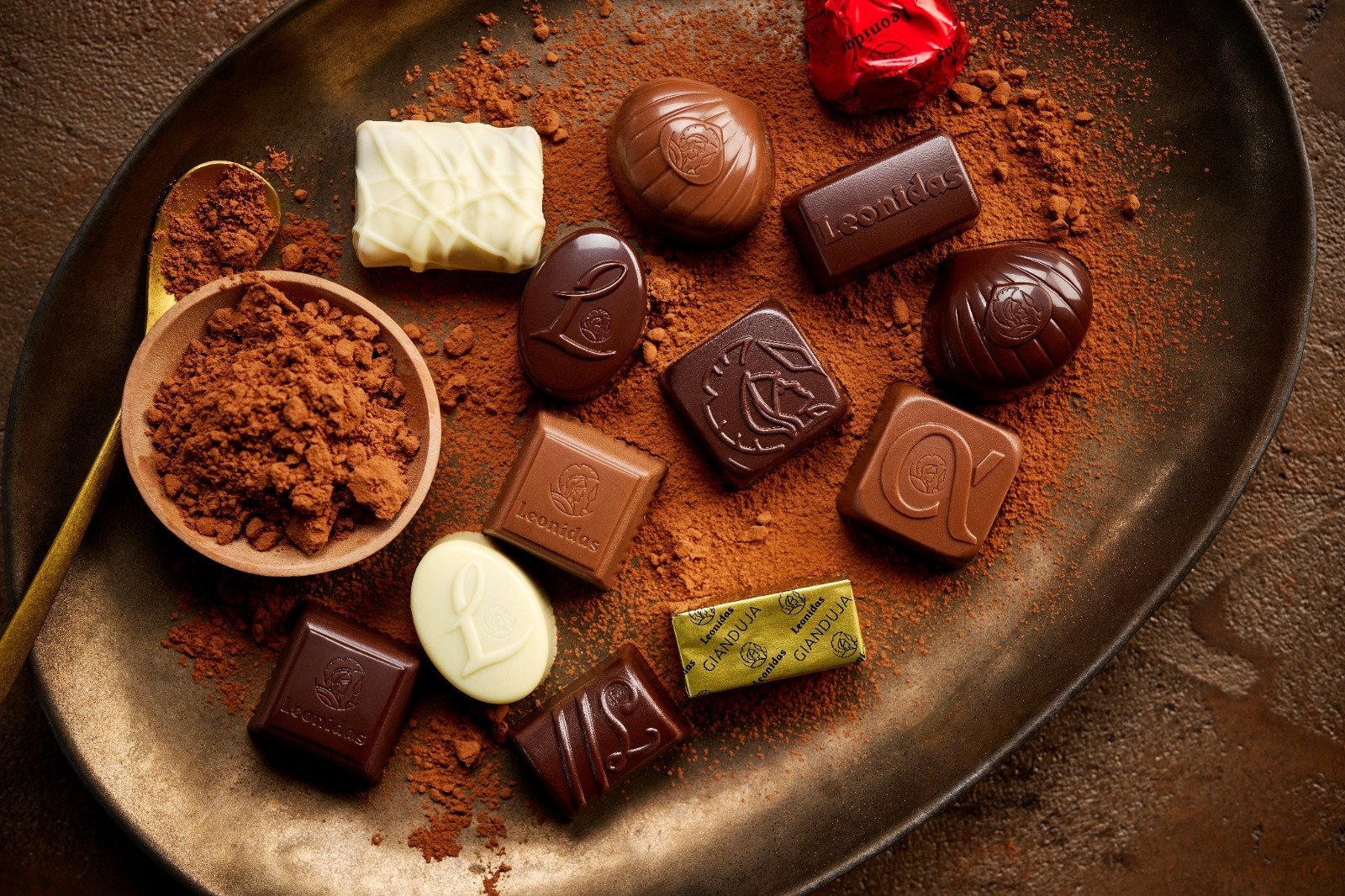 Leonidas pralines resting on a bed of cocoa powder