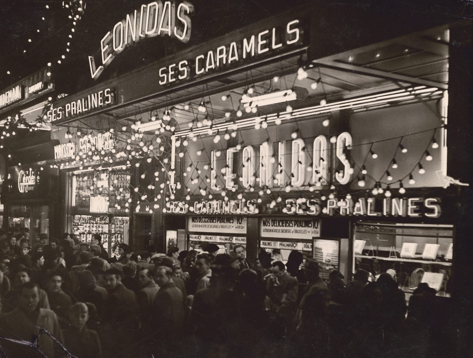 Crowds at night outside the Leonidas shop on Boulevard Anspach, Brussels